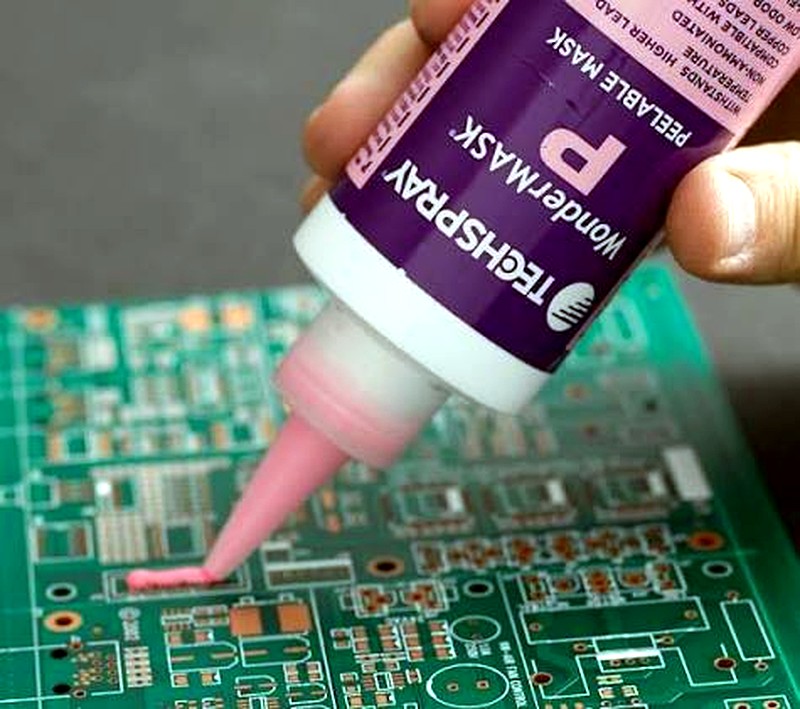 Peelable solder mask being applied to a populated PCB