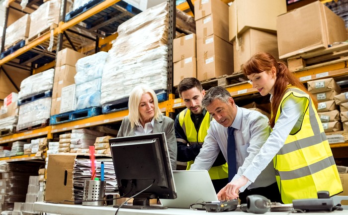 Warehouse team reviewing stock on a laptop